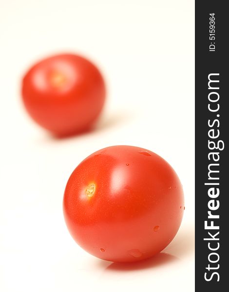 Fresh red juicy tomatoes with water droplets on white background