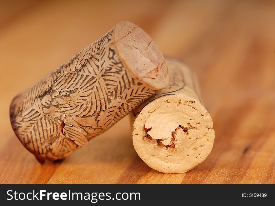 Wine corks on a wood surface with one resting on another. Wine corks on a wood surface with one resting on another