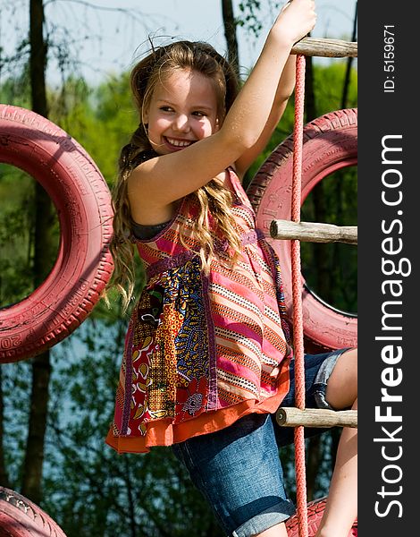 Young girl is smiling while playing on the playground. Young girl is smiling while playing on the playground