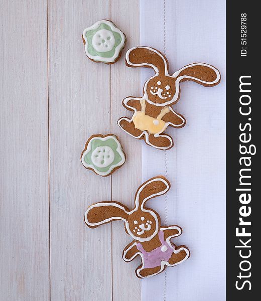Easter Bunny and green flower cookies on the white wooden background