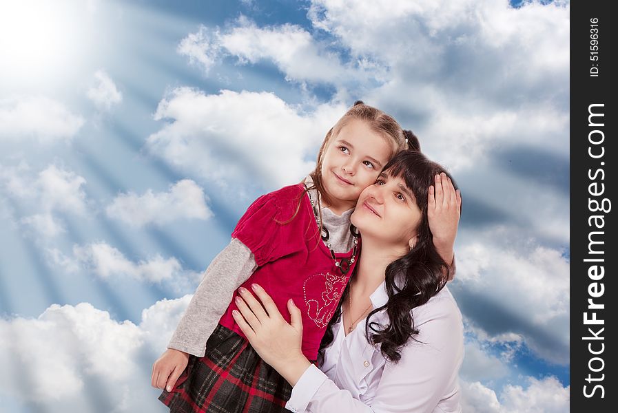 Young mother and her little daughter looking up on cloudy background. Young mother and her little daughter looking up on cloudy background