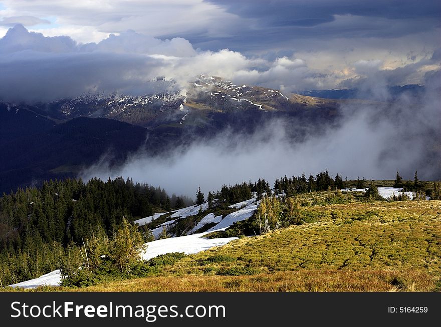 Snowy and rocky hill in a cloud.