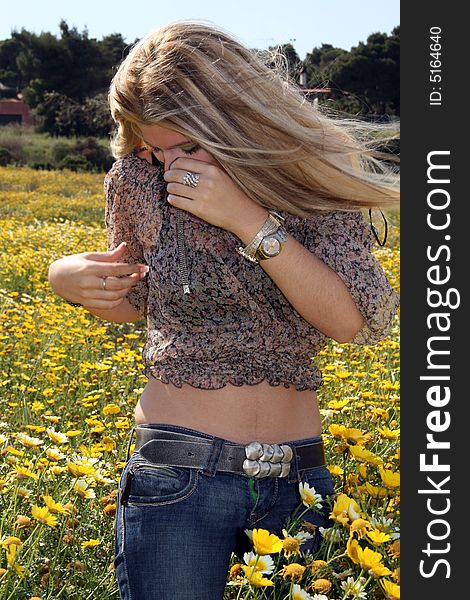 A young beautiful blonde woman in a daisy field. A young beautiful blonde woman in a daisy field