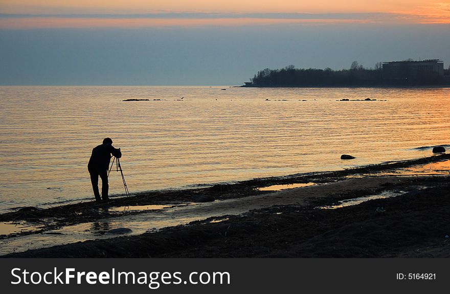 The man making photo of a sea landscape. The man making photo of a sea landscape