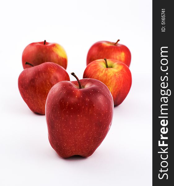 Five apples on white background with shallow depth of field