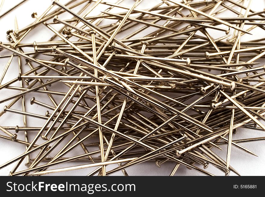 Heap of sewing pins scattered on white background