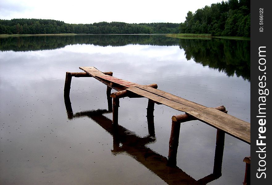 Old wooden pier on a  lake in the evening