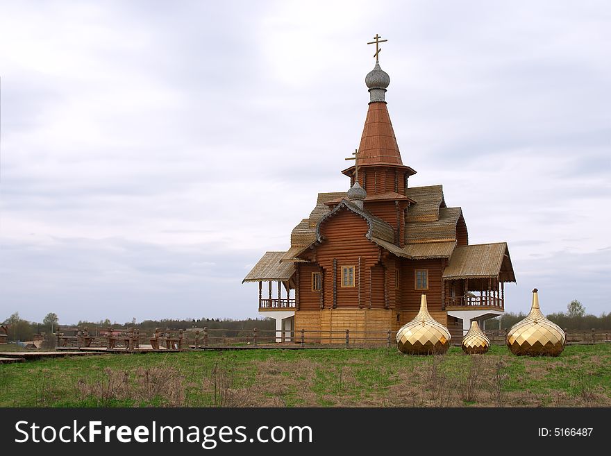 Three golden dome on the ground near wooden chapel