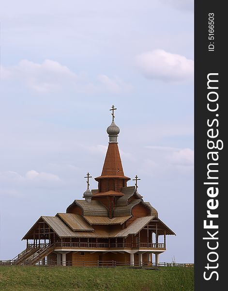 Small wooden church over blue sky with clouds. Small wooden church over blue sky with clouds