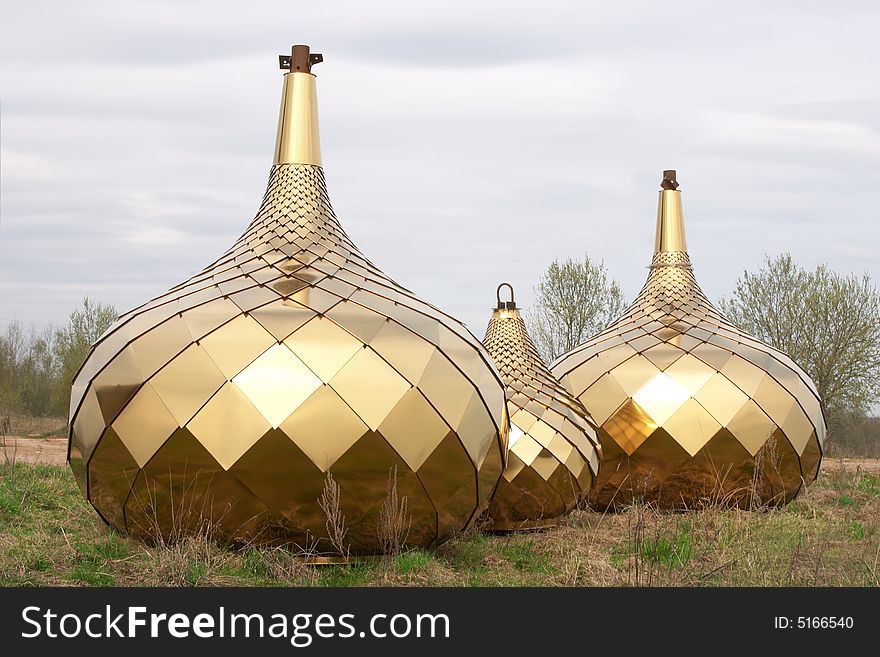 Three golden dome on the ground over blue sky