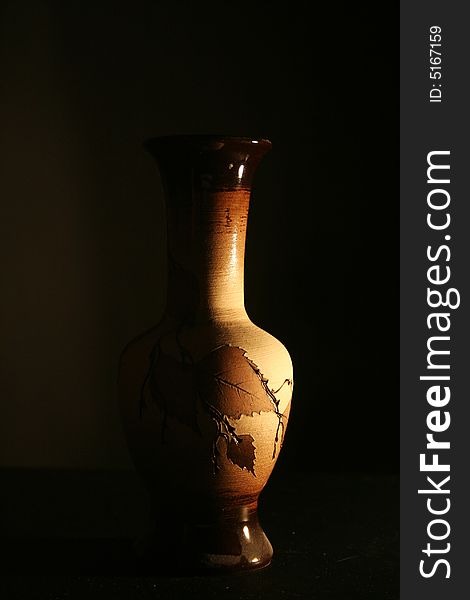 An old wooden vase on the black background. An old wooden vase on the black background