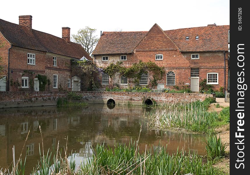 An old English Mill with a pond in front of it