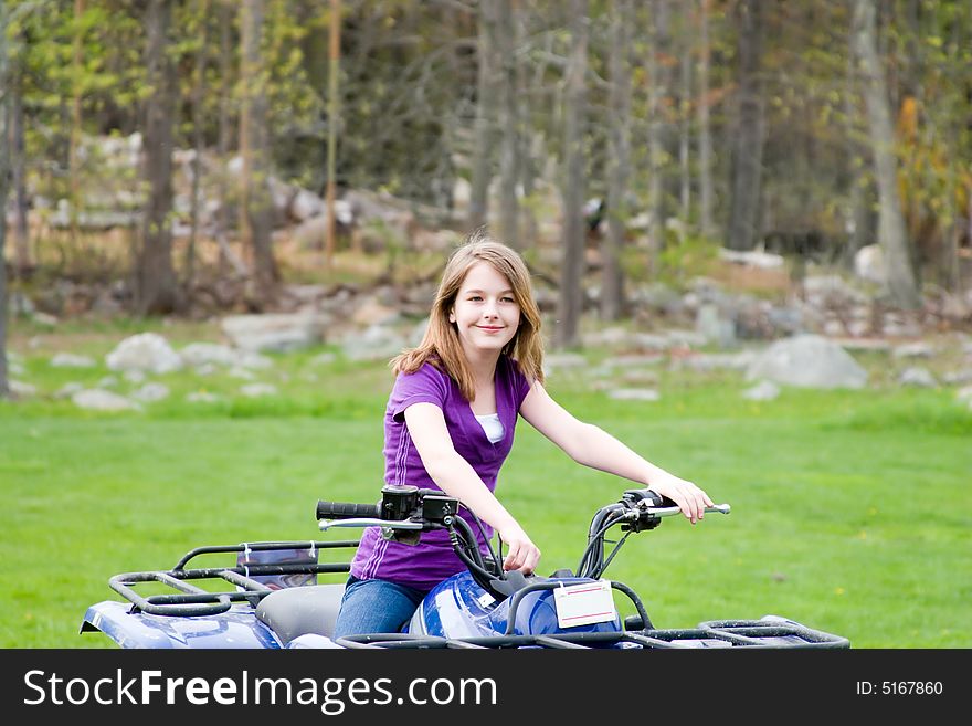 A girl sitting on her 4 wheeler. A girl sitting on her 4 wheeler