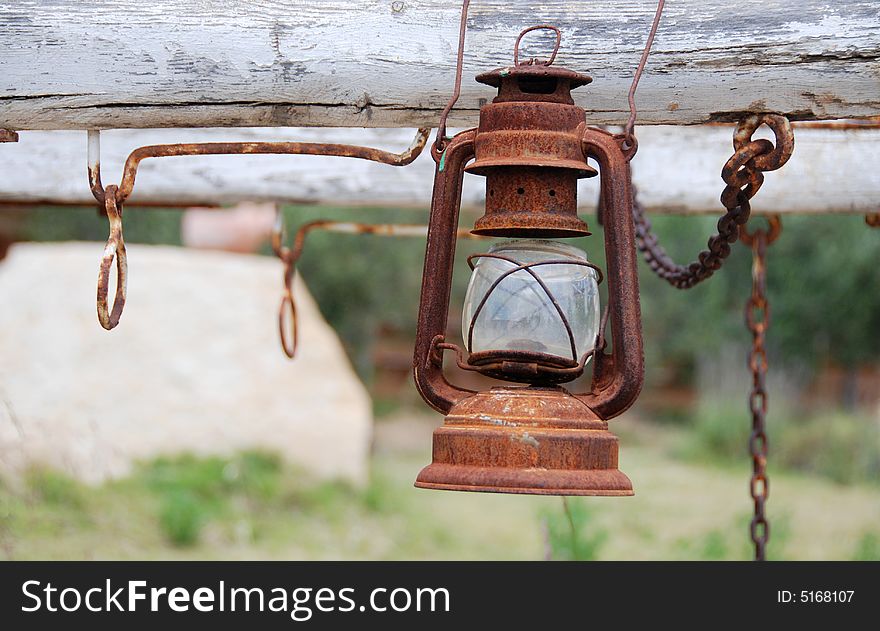 View of a rusty oil lamp hanging on a western carriage. View of a rusty oil lamp hanging on a western carriage