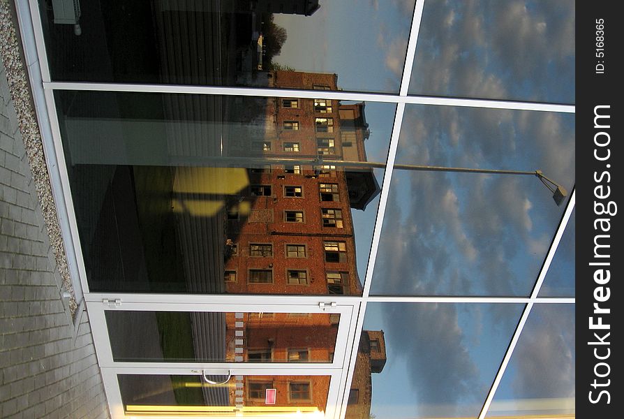 Old factory mirror reflection in the modern office windows. Old factory mirror reflection in the modern office windows