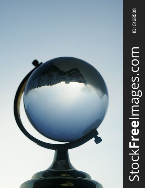 A small globe statuette on a blue sky background. A small globe statuette on a blue sky background