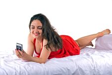 Girl In Red Dress Lying With Cellphone Stock Image