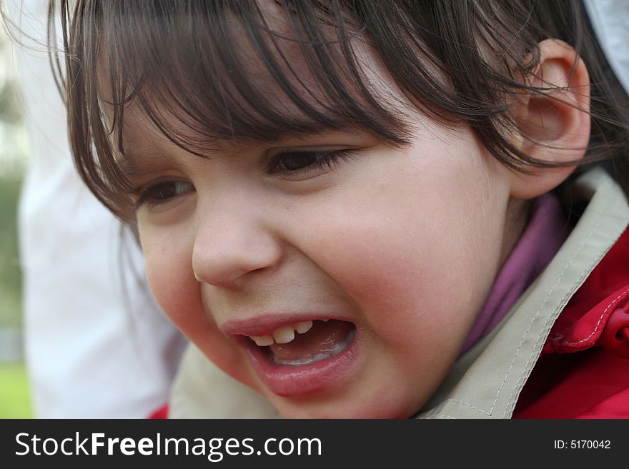 Little girl is crying outdoors in spring park