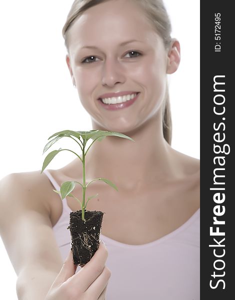 Young woman holding young sprout in the hands.