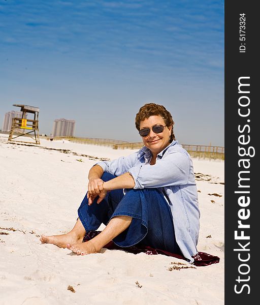 Mature woman relaxing on a sunny white sand beach. Mature woman relaxing on a sunny white sand beach