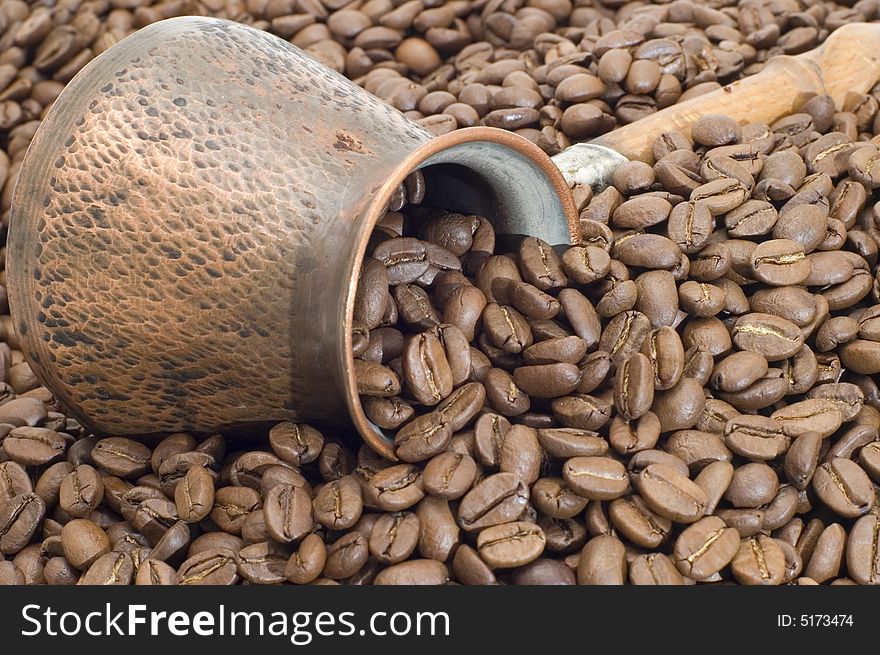 Turkish coffee pot on a background of coffee grains. Turkish coffee pot on a background of coffee grains.