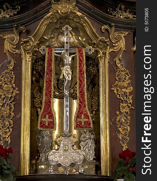 Silver crucifix on an altar decorated with golden ornaments. Silver crucifix on an altar decorated with golden ornaments