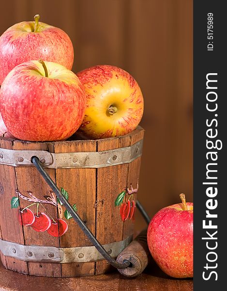 Fresh apples in bucket against wooden background