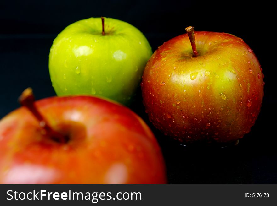 Red & green apples isolated against a black background