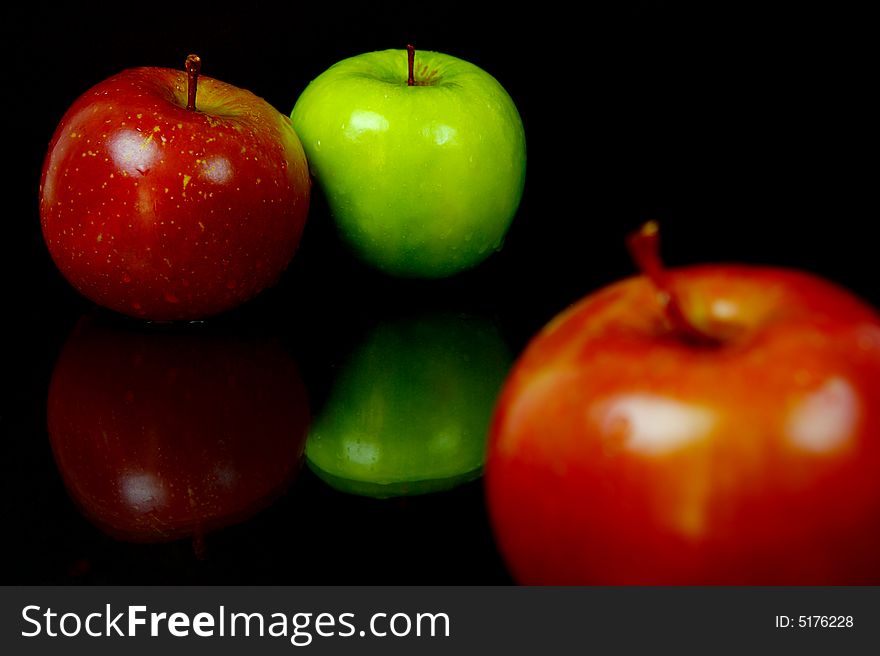 Red & green apples isolated against a black background