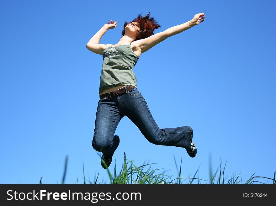 Young girl jumping on a grass. Young girl jumping on a grass