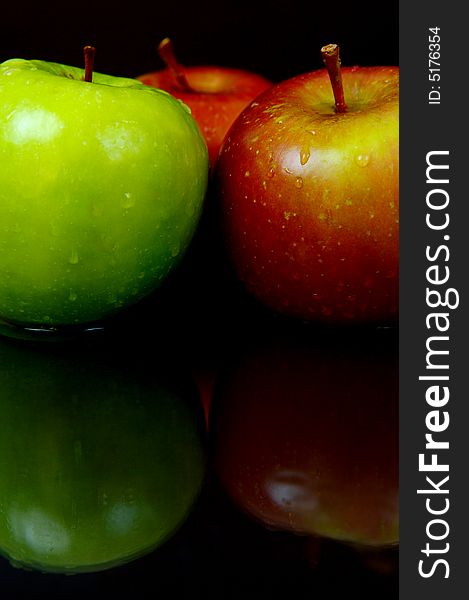 Red & green apples isolated against a black background