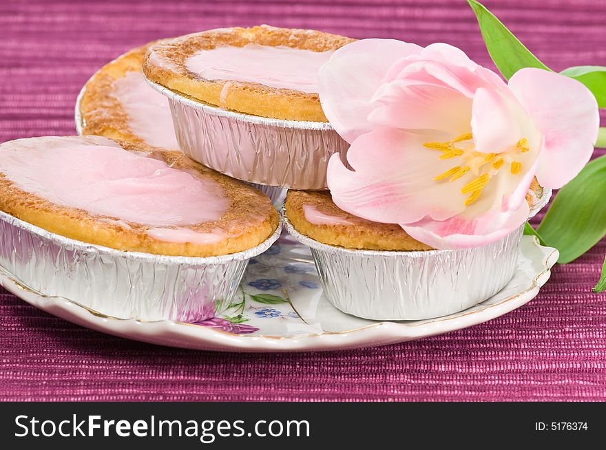 Cakes with raspberry frosting decorated with pink tulip. Cakes with raspberry frosting decorated with pink tulip