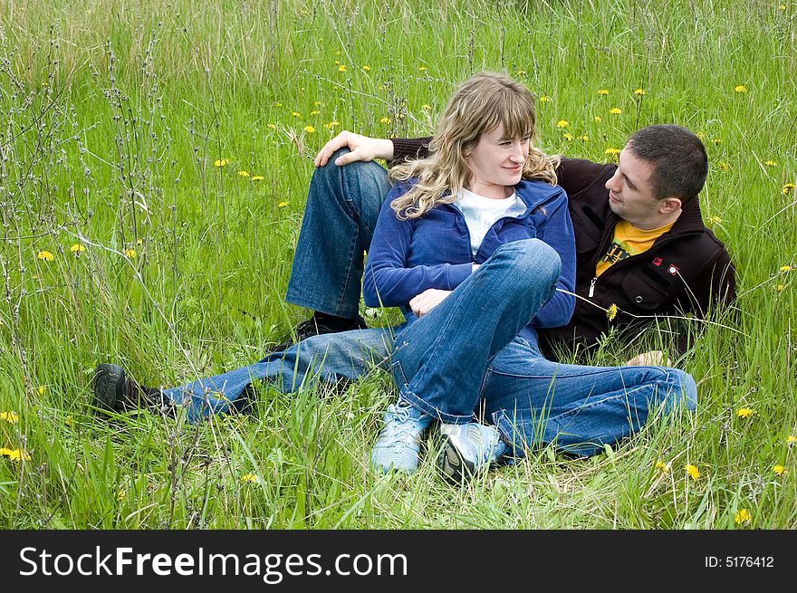 Girl and  guy lay on a grass