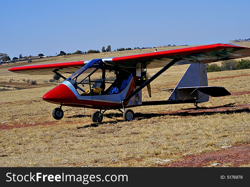 Light aircraft [Challenger microlight] parked on the side, out of the hub bub during an air show