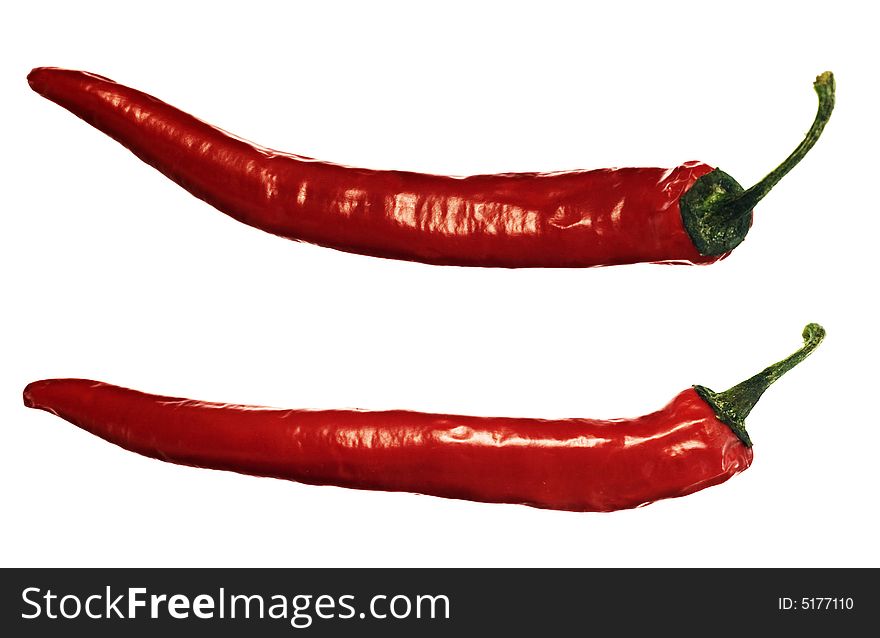 Two red hot peppers over white