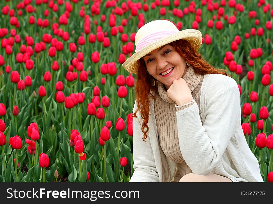 Portrait of a beautiful young woman on a garden of tulips. Portrait of a beautiful young woman on a garden of tulips