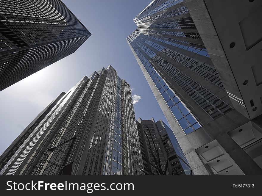 A group of soaring office towers, shaded in blue and grey. A group of soaring office towers, shaded in blue and grey.