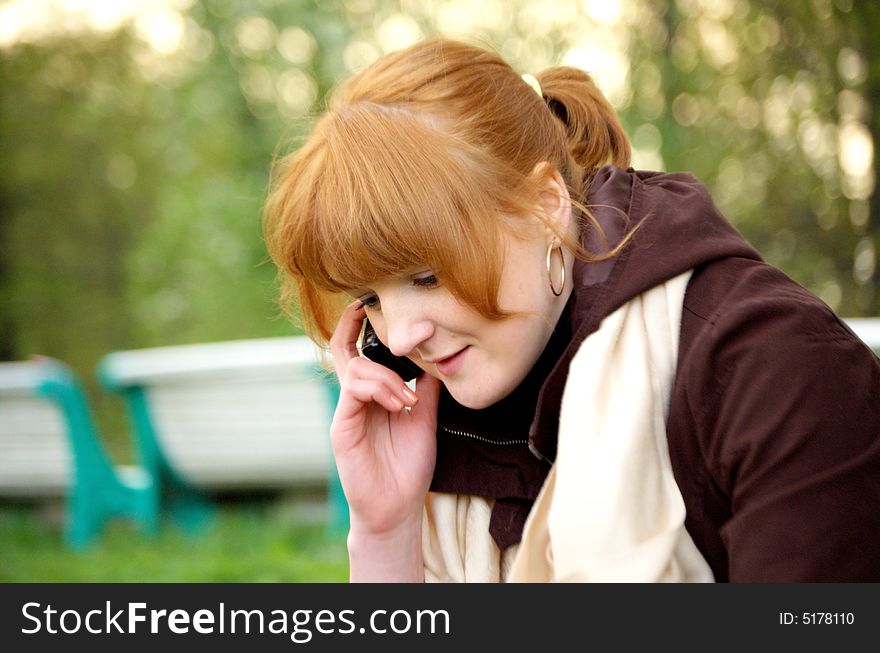 Girl in a garden with a cellular phone. Girl in a garden with a cellular phone.