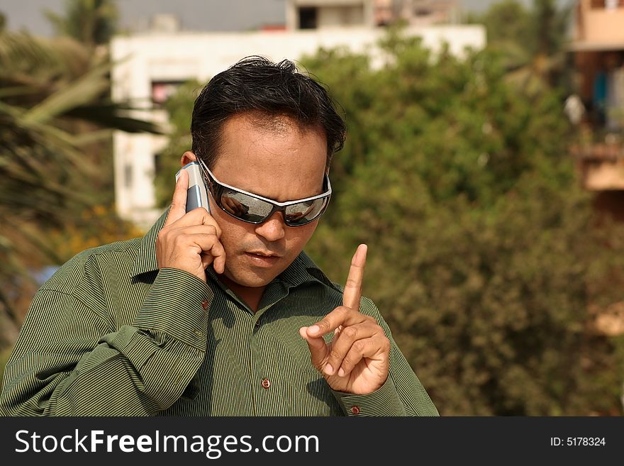 A young man giving instructions over the phone. A young man giving instructions over the phone.