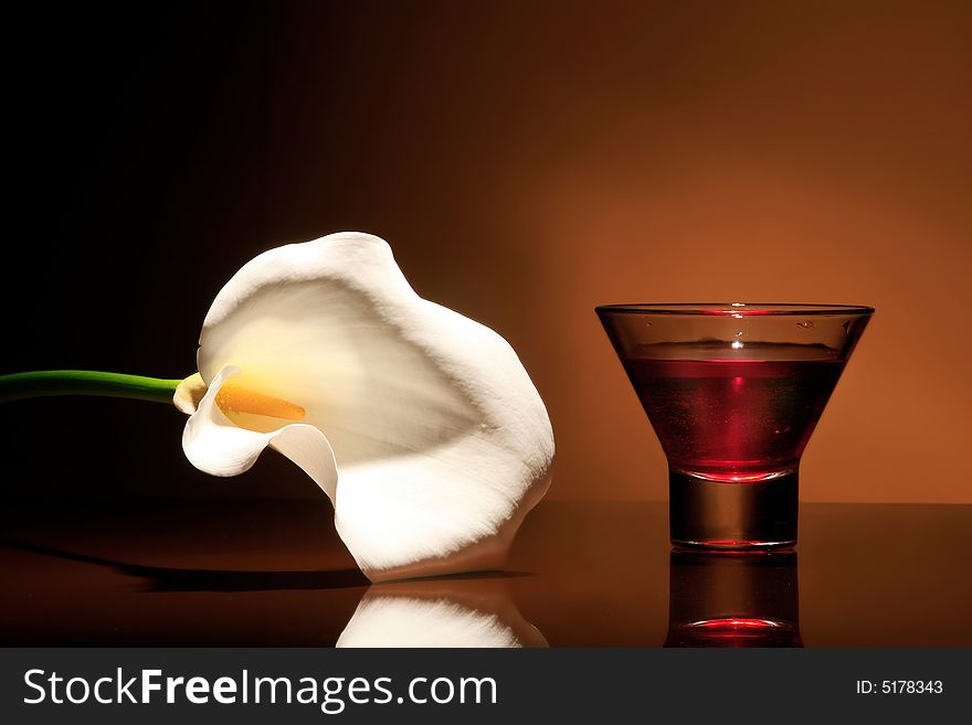 A glass with white flower on orange. A glass with white flower on orange