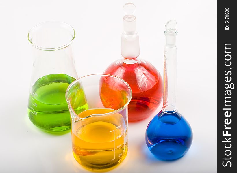 Various colorful flasks over white background