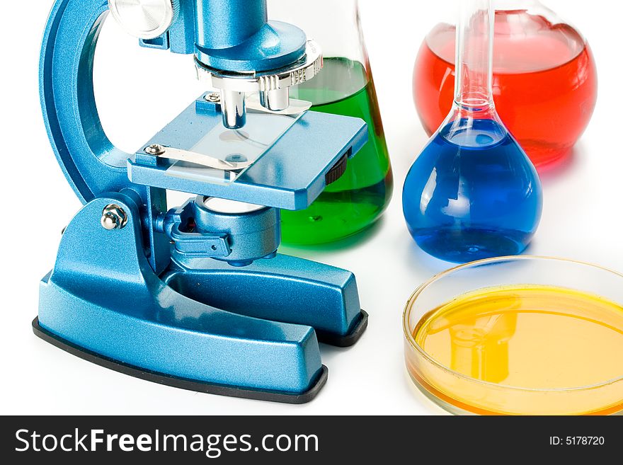 Various colorful flasks and blue microscope over white background