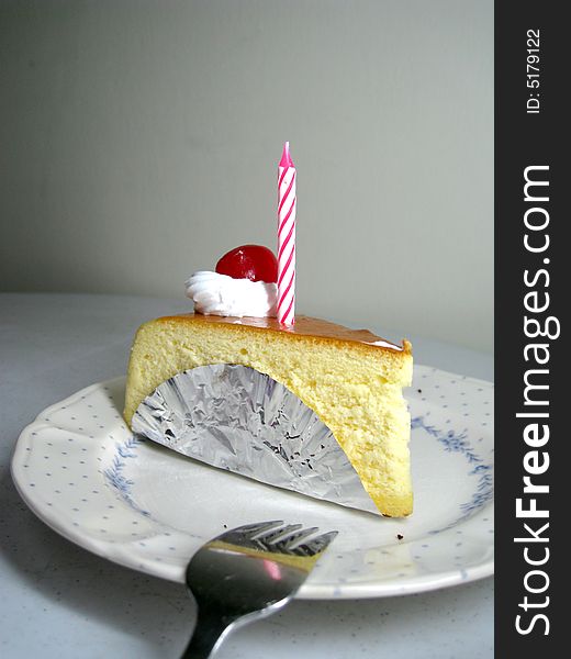 A slide of cheese cake with candle on top