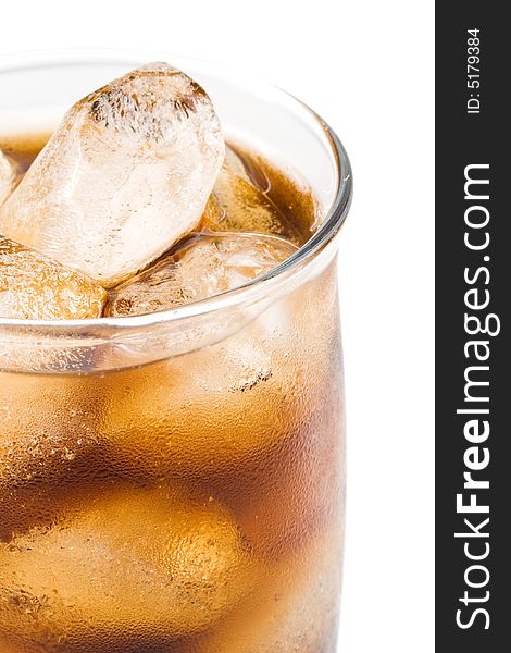 Cold fizzy cola with ice in a glass. Close up.