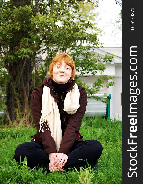 Girl sitting cross-legged in a garden. Girl sitting cross-legged in a garden