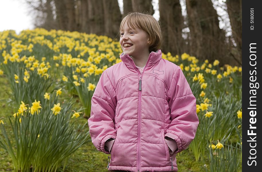 Girl outdoors against a backdrop of yellow daffodils. Girl outdoors against a backdrop of yellow daffodils