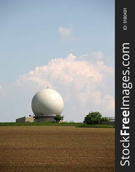 A landscape with an army radar and a field in the front