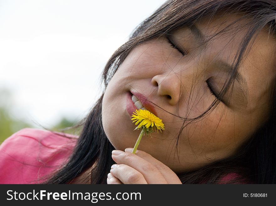 Young attractive woman play with yellow dandelion. Young attractive woman play with yellow dandelion