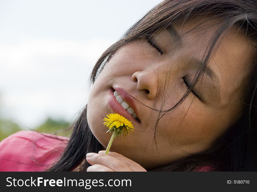 Young attractive woman play with yellow dandelion. Young attractive woman play with yellow dandelion