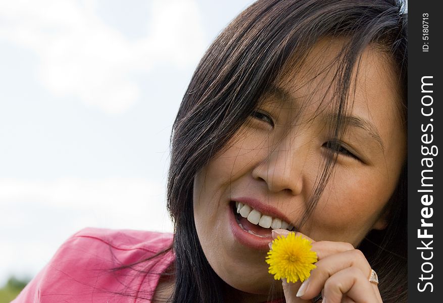 Young attractive woman play with yellow dandelion. Young attractive woman play with yellow dandelion